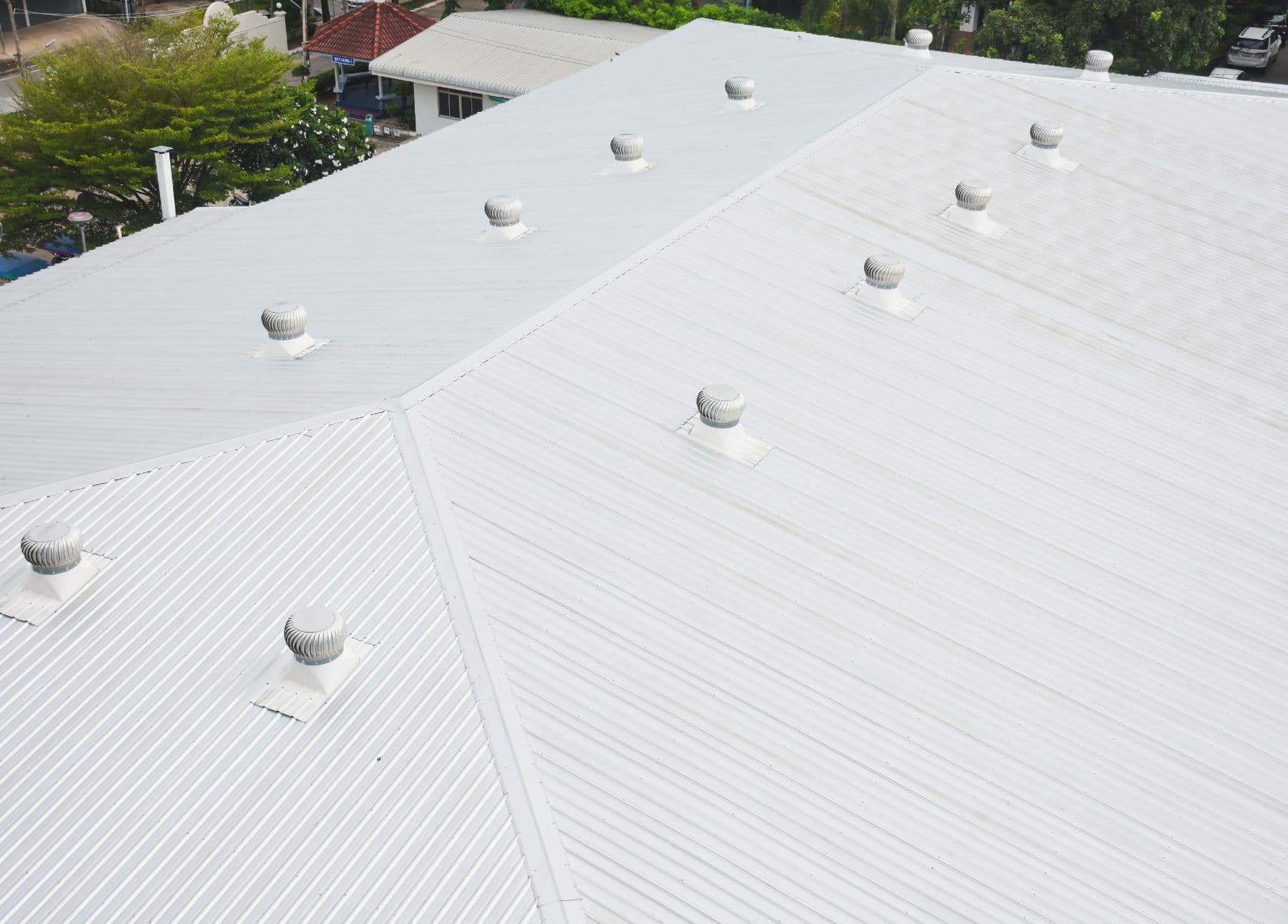 Light-colored metal roof with multiple rooftop vents