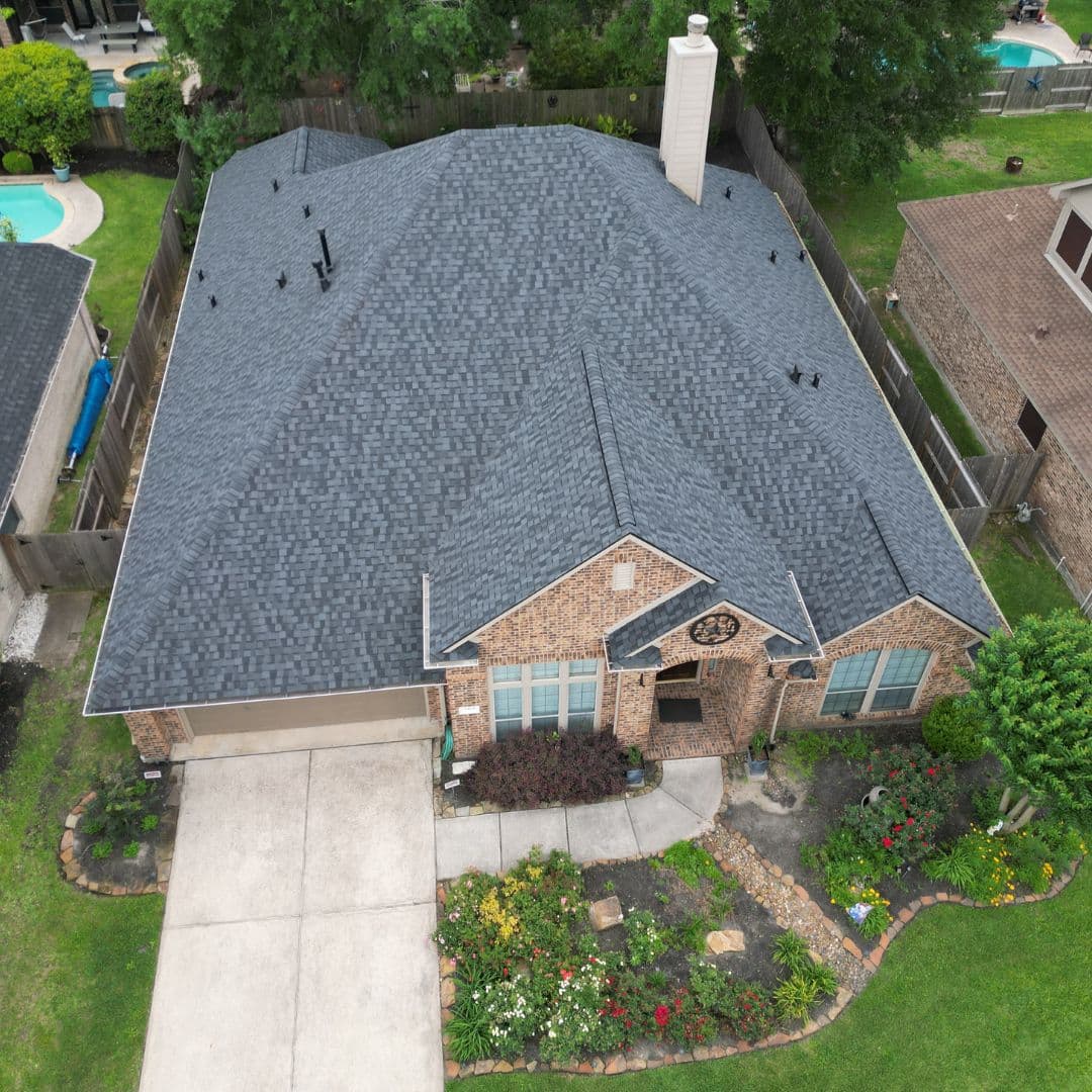 Aerial view of a dark shingle roof on a brick house